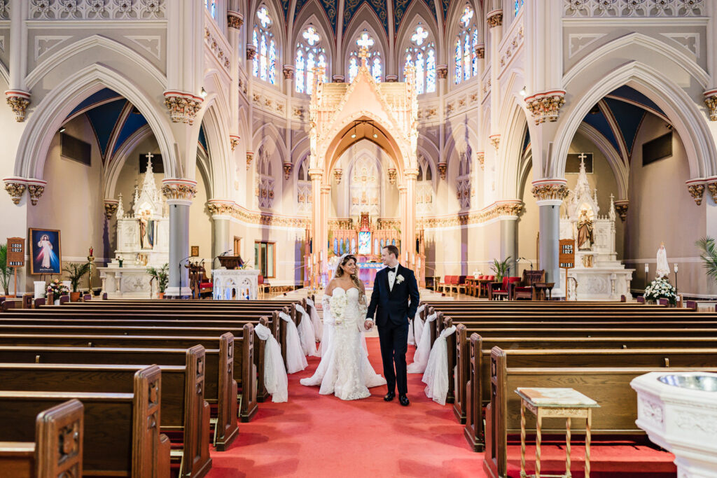 Bride and groom walking down aisle after ceremony recessional at St. Henry's Church Bayonne wedding by Alex Kaplan Photography