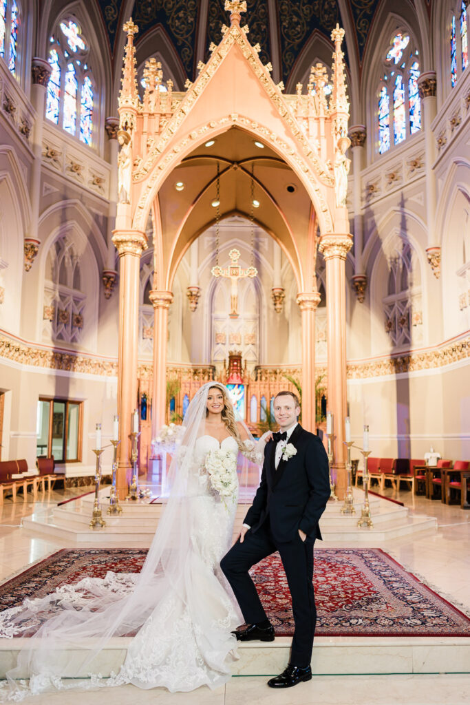 Bride and groom wedding portraits at ornate altar of St. Henry's Church Bayonne with Neo-Gothic architecture by Alex Kaplan Photography