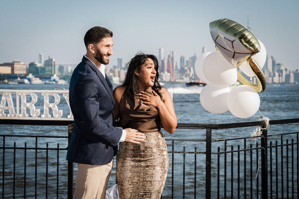 Bride's emotional reaction during Chart House Weehawken surprise proposal photographed by Alex Kaplan