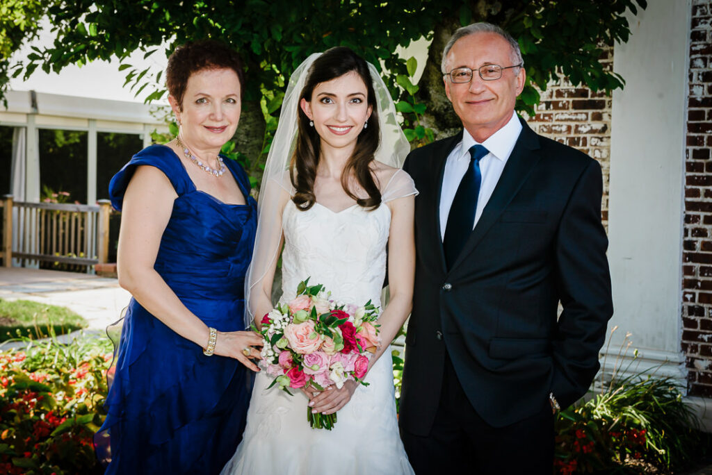 Jewish bride standing with mother and father before ceremony in Hamilton Farm gardens