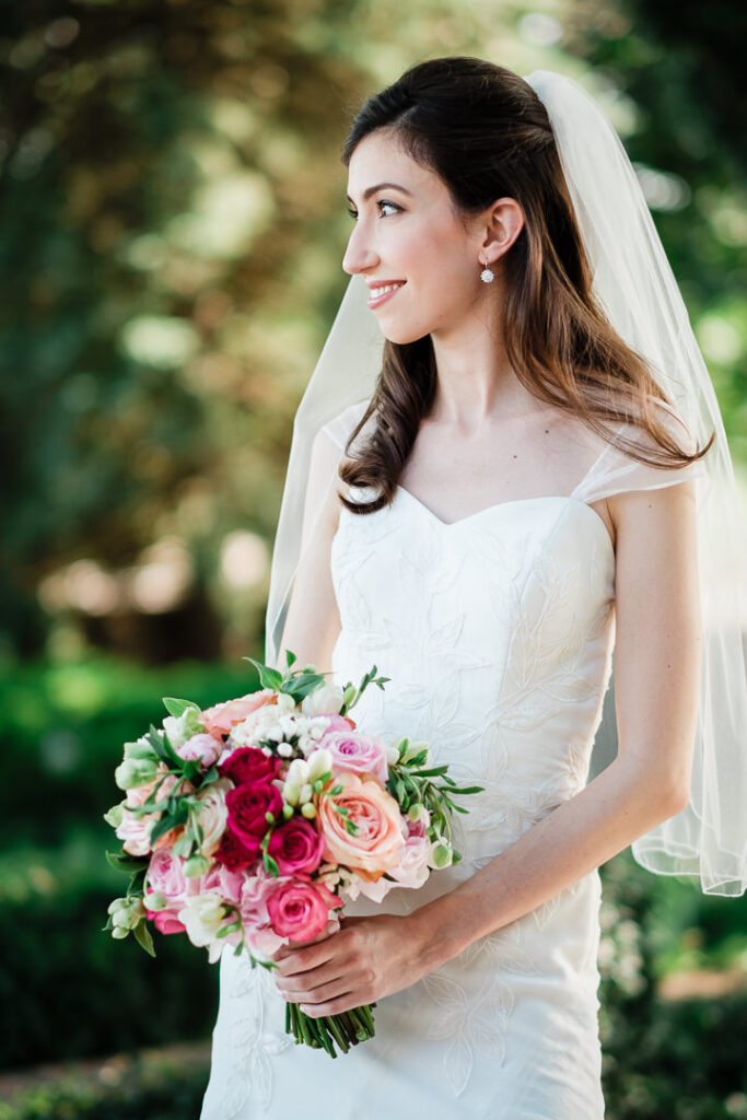 Elegant side profile of bride with flowing veil and romantic bouquet in soft natural lighting