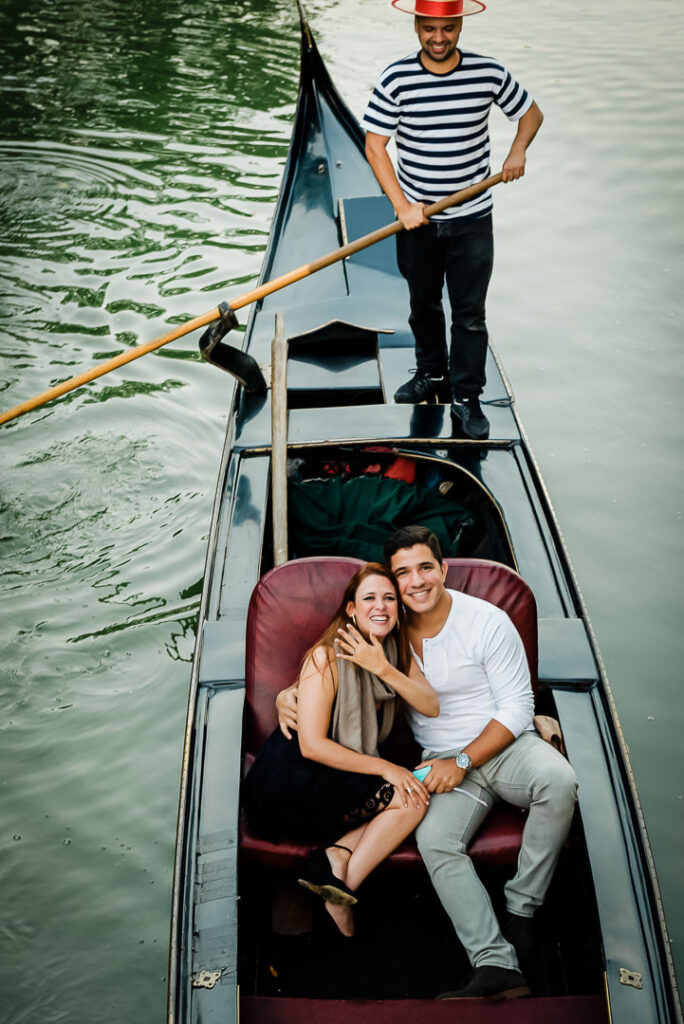 Gondolier navigating traditional Venetian gondola during engagement photo session at Loeb Boathouse Central Park