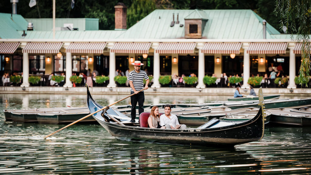 Engaged couple sitting in gondola at Central Park Loeb Boathouse during proposal captured by NYC wedding photographer