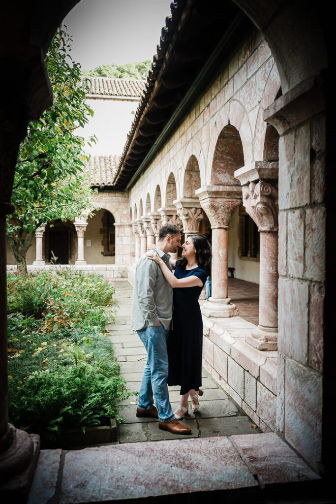 Couple standing in medieval stone archway with carved columns at The Cloisters museum