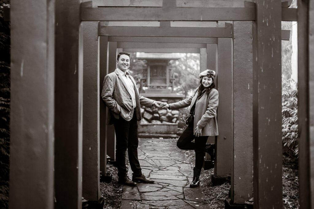 Black-and-white engagement portrait creatively framed through traditional doorway at Mount Fuji.