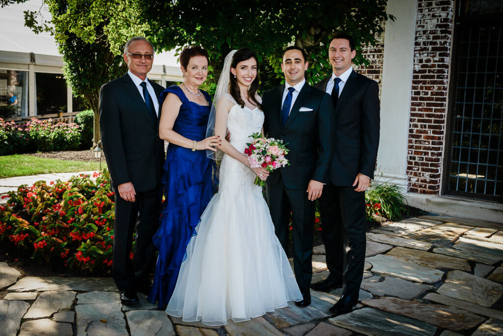 Multi-generational family portrait with bride, groom, and family members in formal wedding attire
