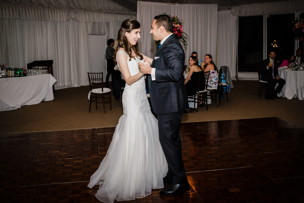 Newlyweds sharing their first dance on elegant parquet dance floor at Hamilton Farm reception