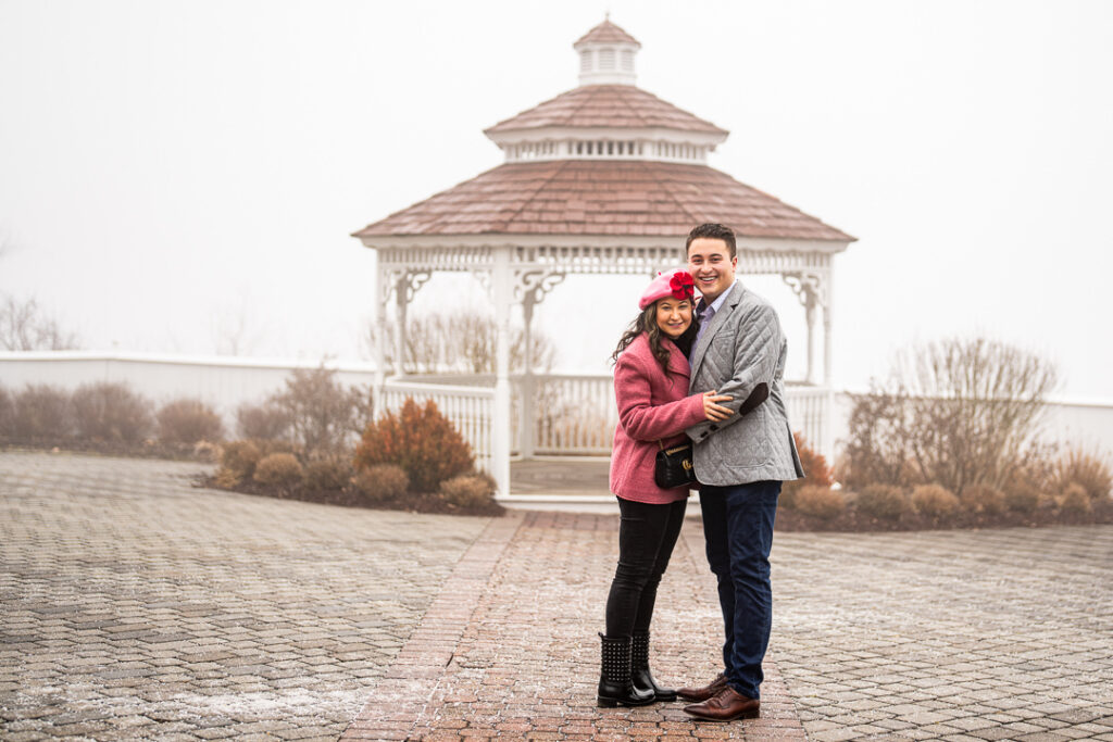 Full-length engagement portrait with white gazebo backdrop at Hillburn, New York venue.