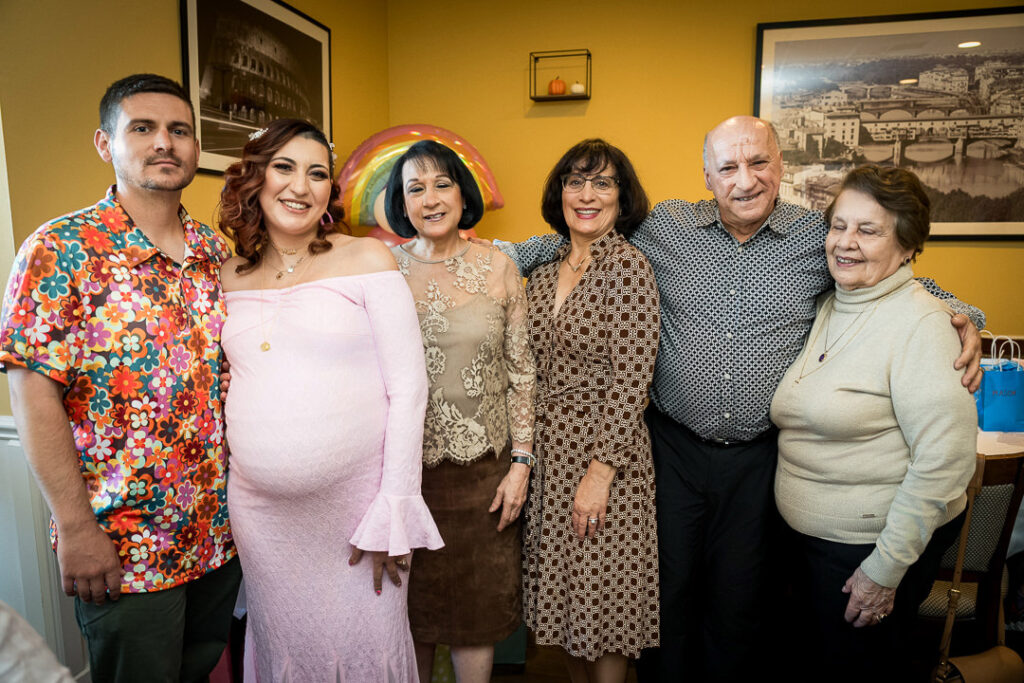 Complete family group including grandparents at groovy girl themed baby shower celebration New Jersey