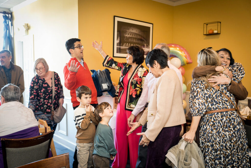 Baby shower guests socializing under rainbow balloon arch at Delpino Restaurant New Jersey