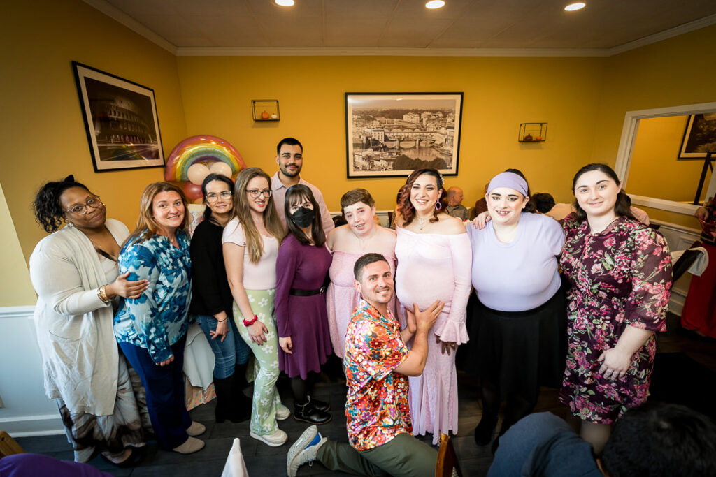 Baby shower guests taking celebratory selfie at groovy themed celebration Delpino Restaurant