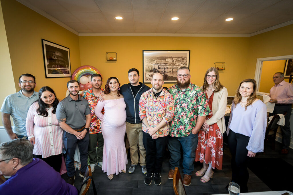 Large group of friends posing at groovy themed baby shower celebration New Jersey