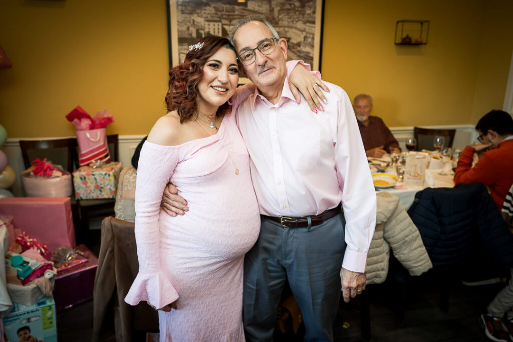 Expecting mom posing with grandfather at groovy baby shower celebration Delpino Restaurant NJ