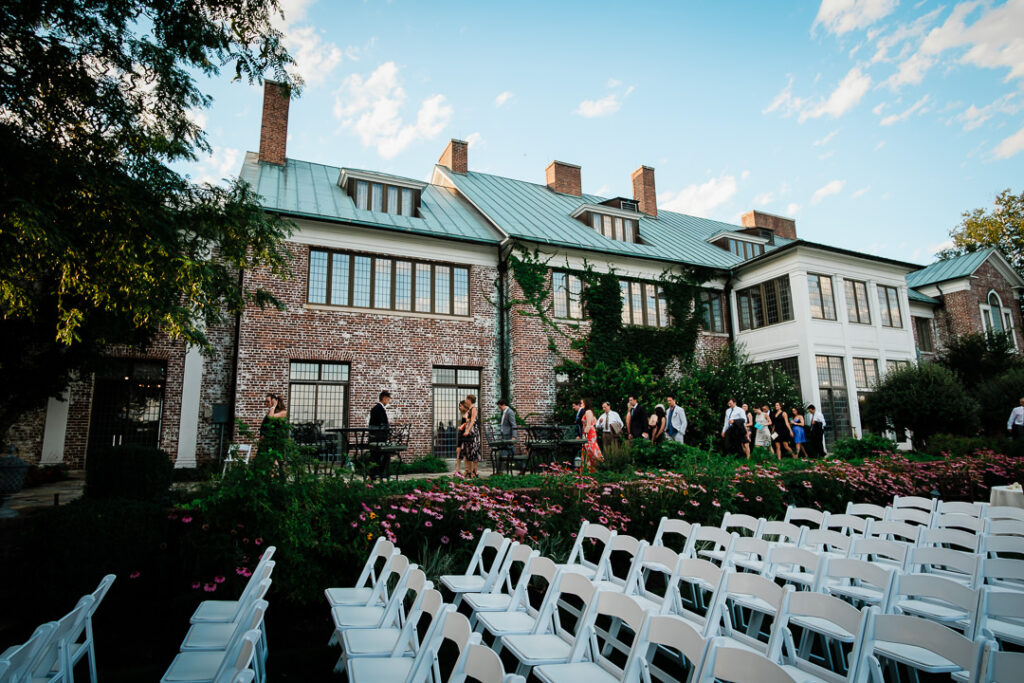Guests mingling during cocktail hour at Hamilton Farm's distinctive copper roof building with white columns