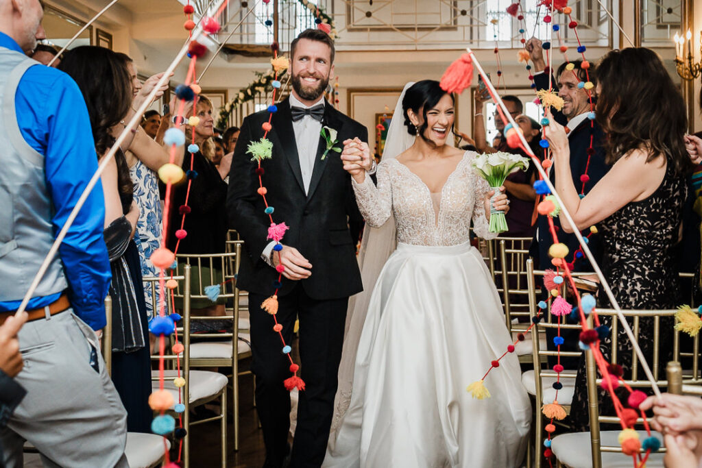 Joyful colorful pom-pom ceremony exit celebration at James Ward Mansion Westfield wedding by Alex Kaplan Photography