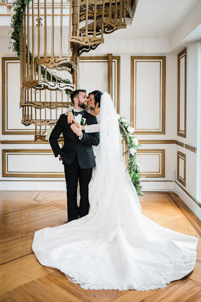 Romantic couple kissing on golden spiral staircase James Ward Mansion Westfield by Alex Kaplan Photography