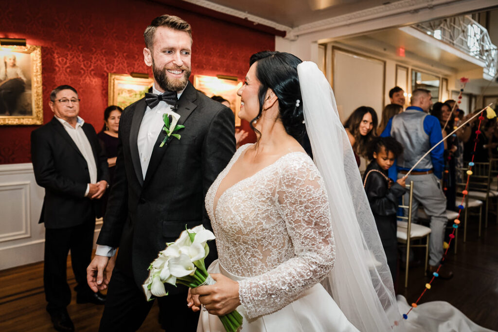 Couple celebrating during reception entrance at James Ward Mansion wedding by Alex Kaplan Photography