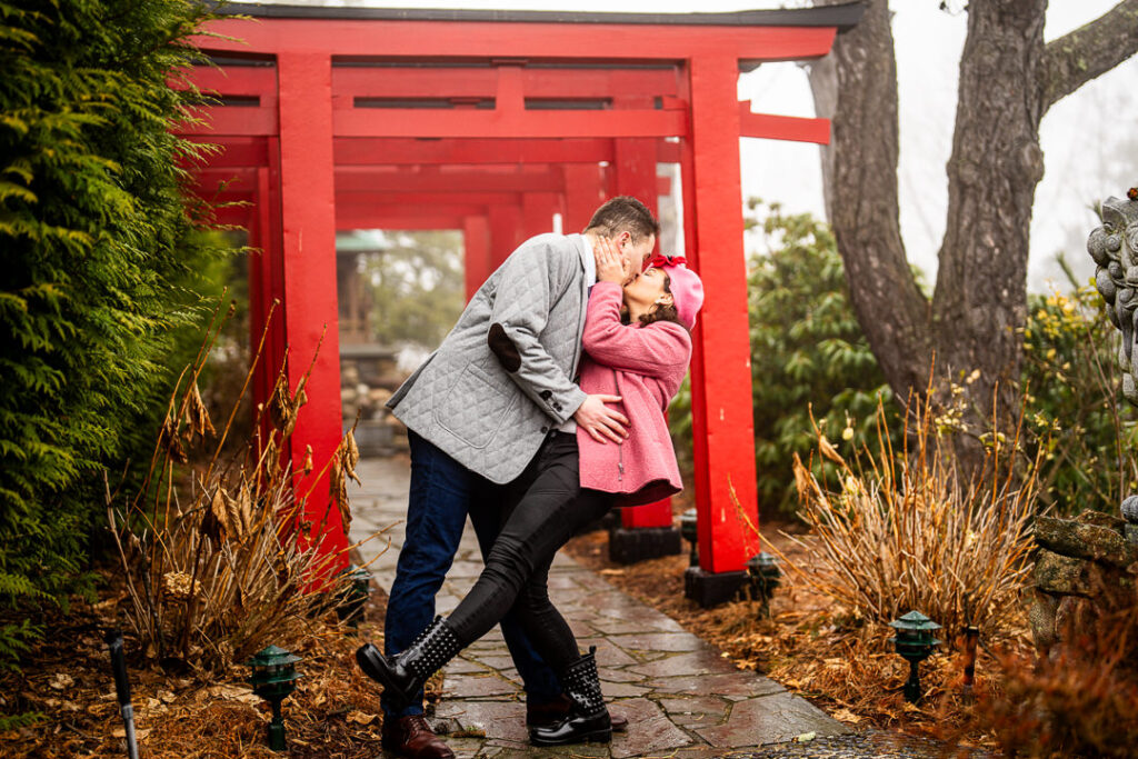 Couple kissing beside bold red torii gate at The Views at Mount Fuji, Hillburn.