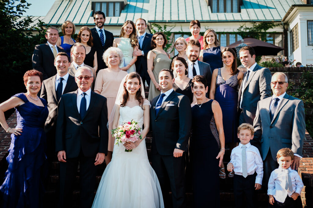 Complete extended family group photo on steps with Hamilton Farm's distinctive copper roof building in background
