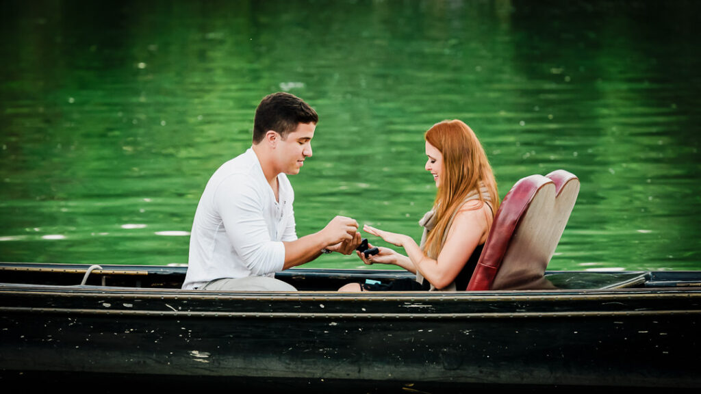 Intimate moment of couple toasting engagement on private gondola at Central Park Loeb Boathouse
