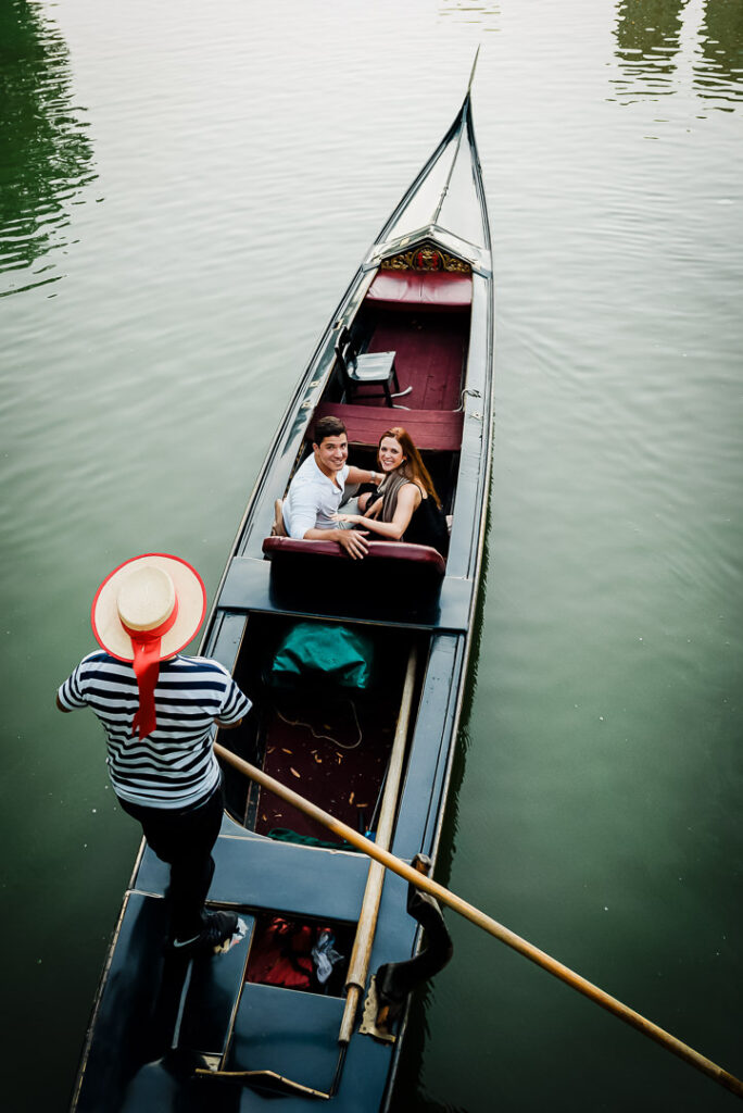 Aerial perspective of engaged couple celebrating in gondola at Central Park with gondolier standing