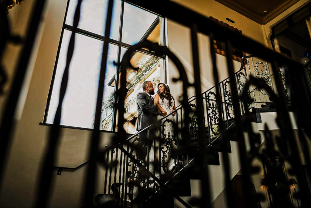 Elegant wedding couple on grand staircase at luxury New Jersey venue captured by Alex Kaplan Photography