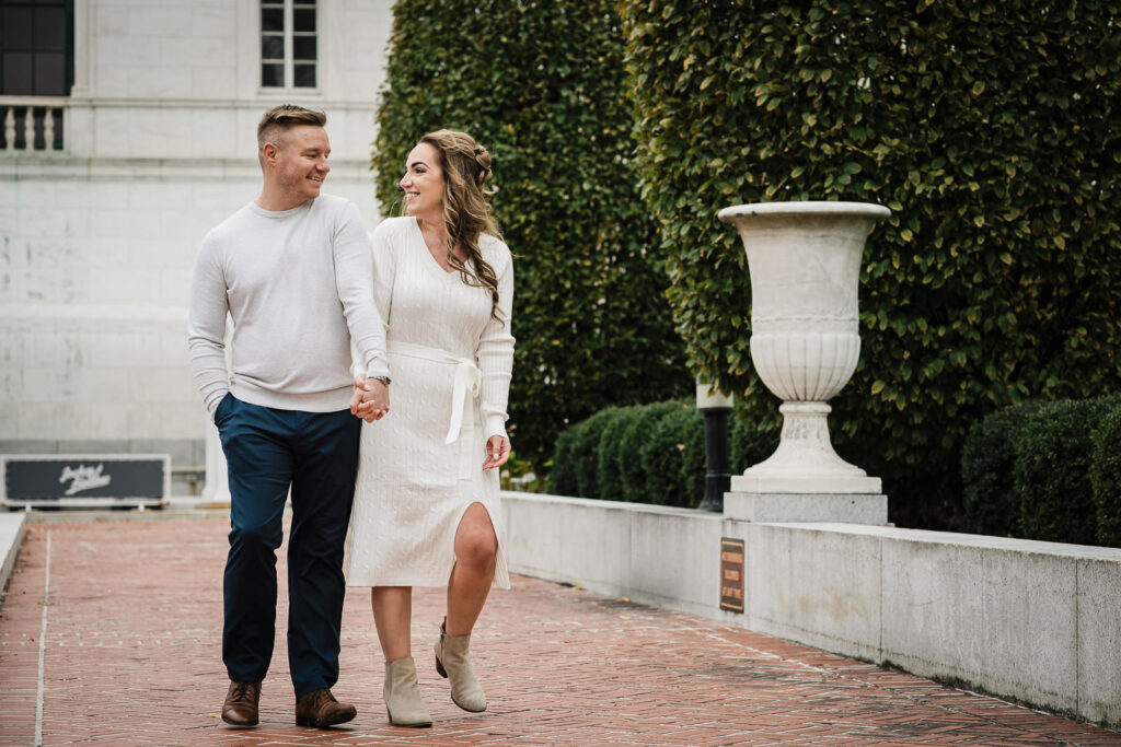 Fall engagement session in Morristown New Jersey with couple walking through autumn leaves in historic downtown