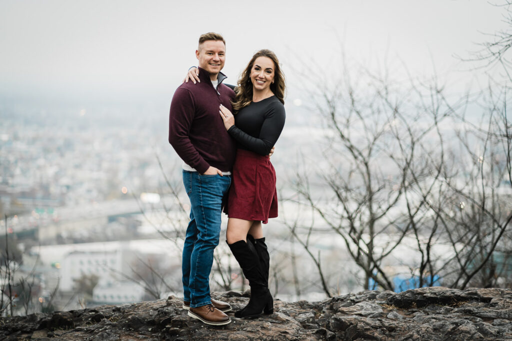 Engagement portrait at Garrett Mountain overlook with scenic view and romantic couple pose during golden hour