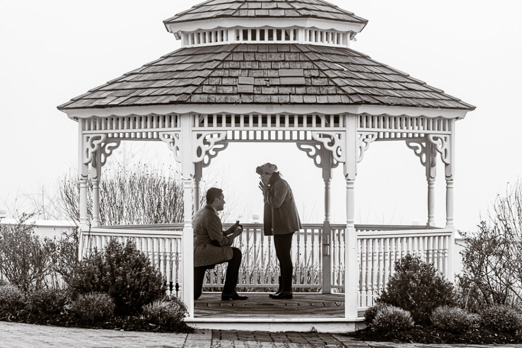 Groom proposes on one knee at white gazebo at The Views at Mount Fuji, NY.
