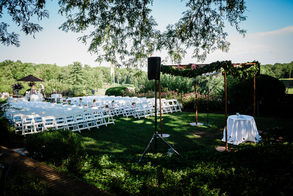 Beautiful outdoor Jewish ceremony setup with wooden chuppah overlooking Hamilton Farm Golf Club's pristine course