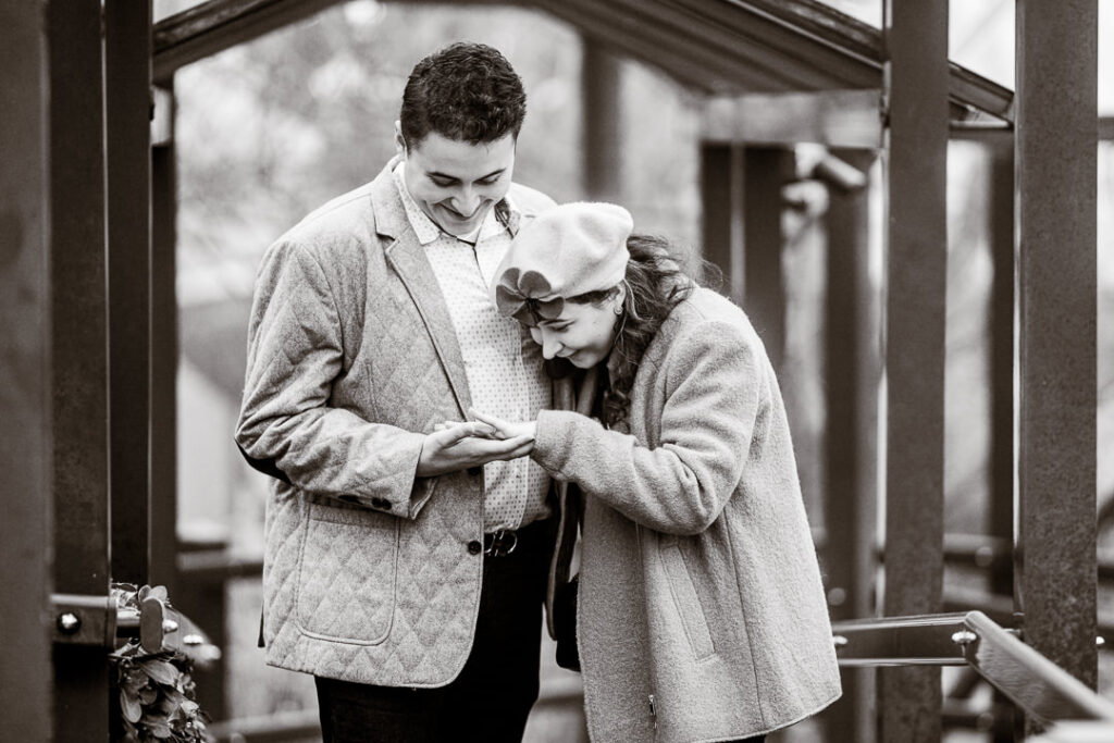 Black-and-white moment of couple admiring engagement ring at Mount Fuji in New York.