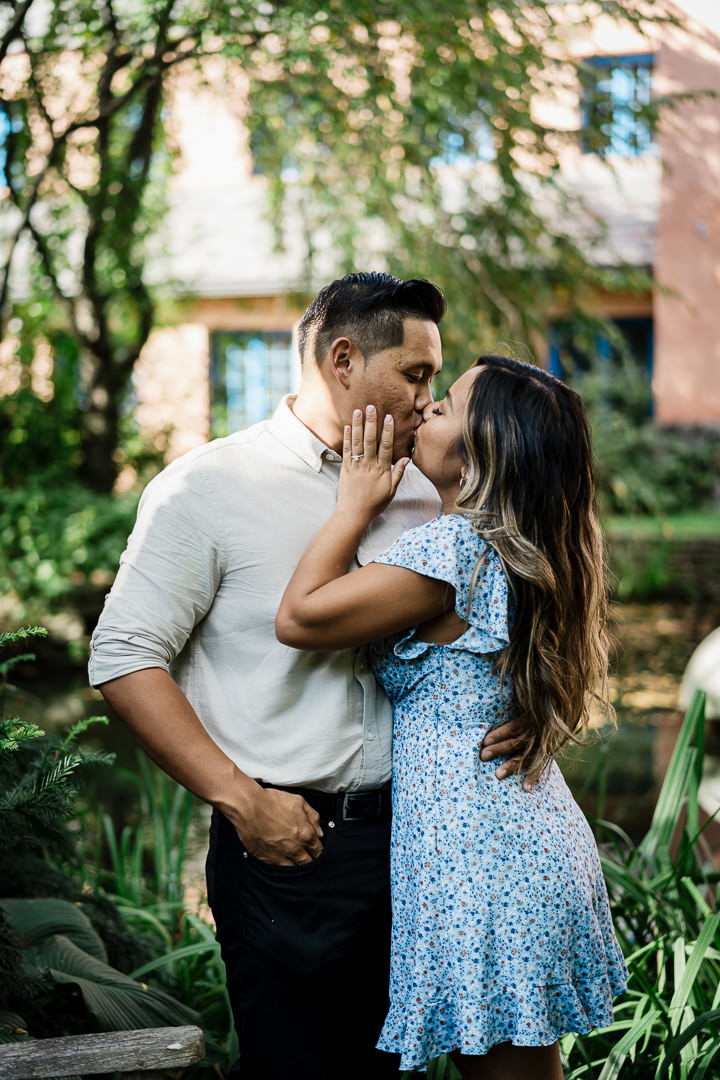 Newly engaged couple kissing outside upscale Jersey City restaurant