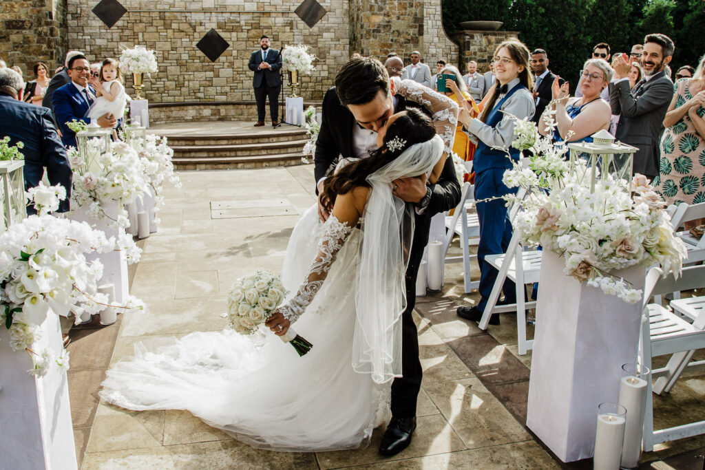 Couple public kissing at stone wall ceremony space The Grand Totowa NJ