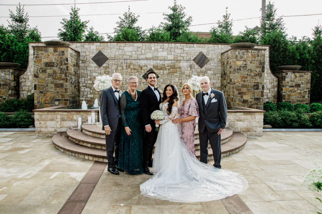 Bridal party celebrating with fists up at fountain The Grand Totowa wedding