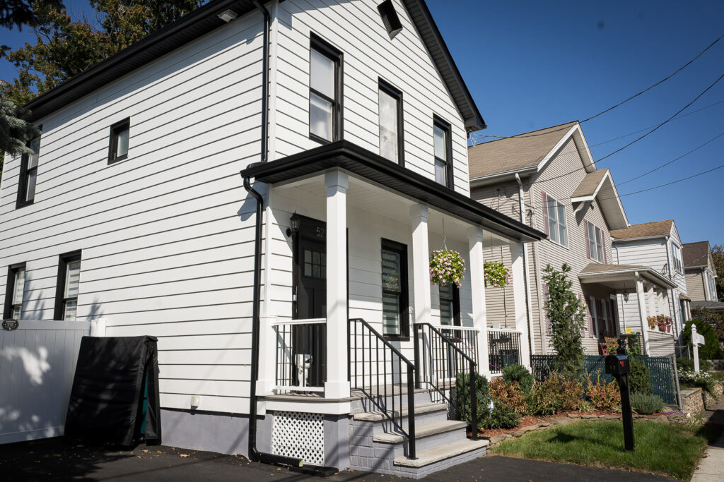 White two-story home with front porch on Heights Ave in Fair Lawn NJ decorated for backyard wedding ceremony