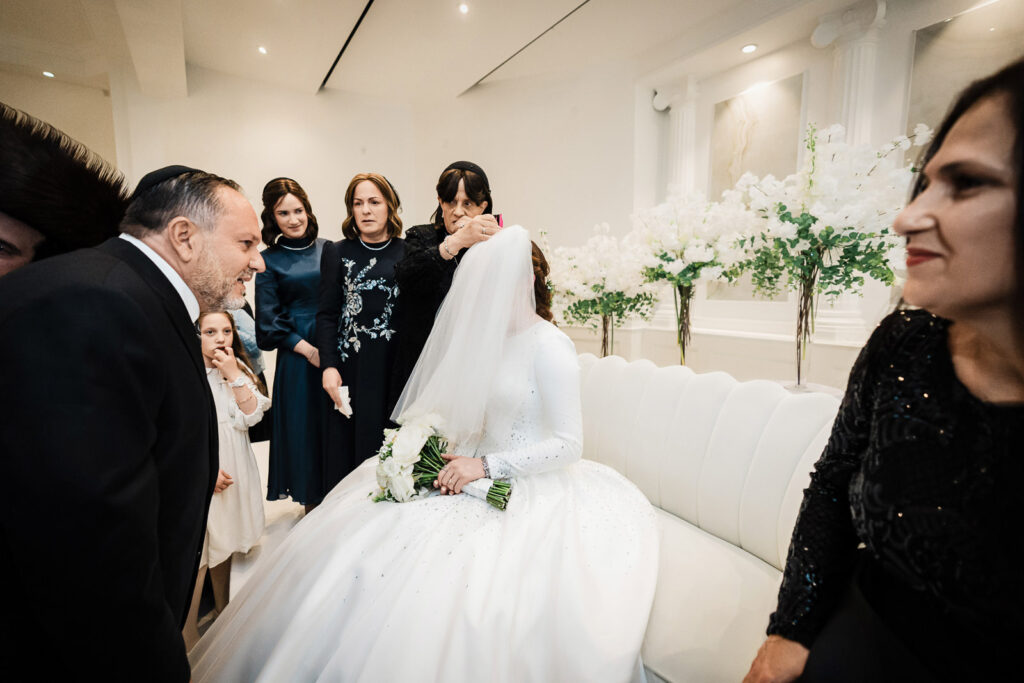 : alex-kaplan-bedeken-ceremony-veiling-bride-riverview-ballroom-orthodox-wedding.jpg Alt Text: Bedeken veiling ceremony at Riverview Ballroom Orthodox Jewish wedding Cliffside Park NJ photographer