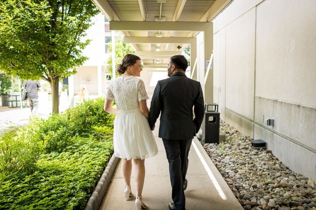 Couple kissing in covered walkway at Bergen County courthouse wedding by Alex Kaplan