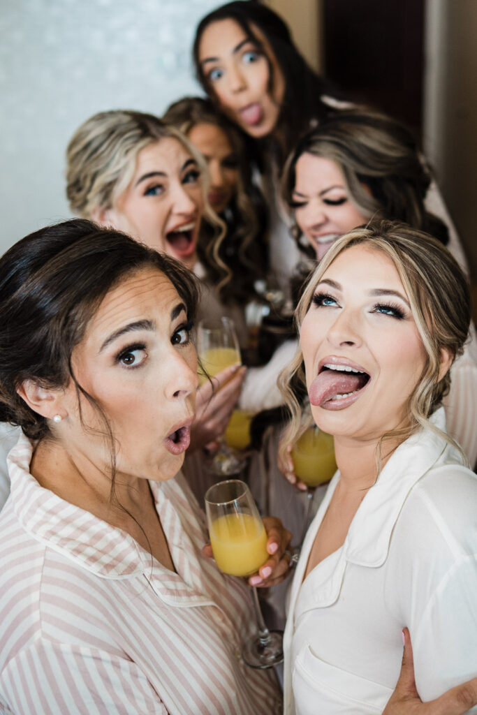 Bridesmaids making silly faces with mimosas during getting ready photos at Westin Mount Laurel captured by NJ wedding photographer Alex Kaplan