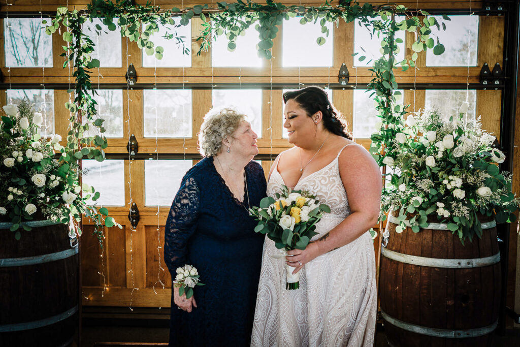 Bride sharing moment with grandmother in front of ceremony backdrop at The Conservatory Sussex County Fairgrounds by Alex Kaplan Photography