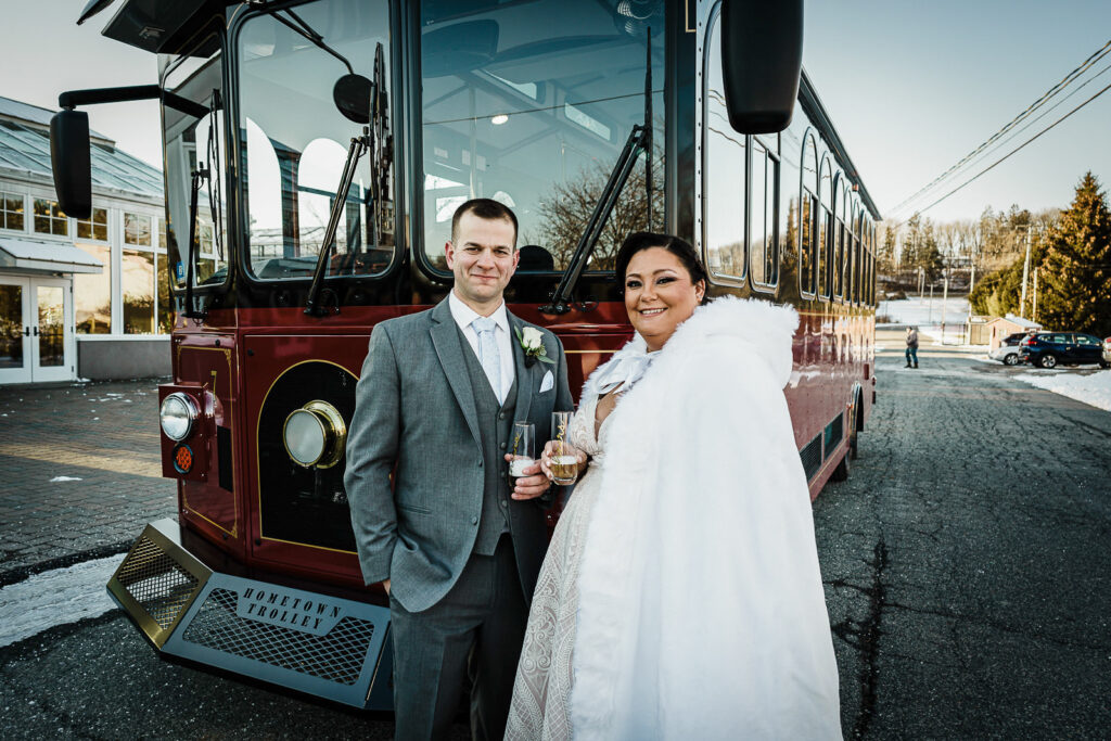 Newlyweds with champagne in front of vintage trolley at The Conservatory Sussex County Fairgrounds by Alex Kaplan Photography