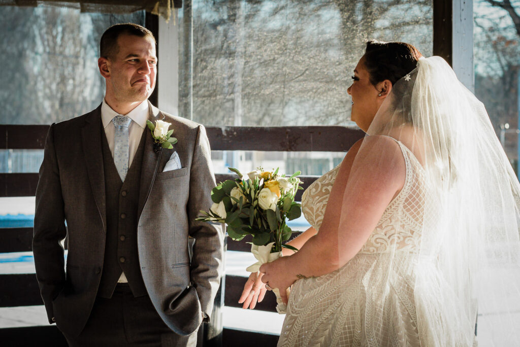 First look moment at ice rink structure with winter backdrop at Sussex County Fairgrounds by Alex Kaplan Photography