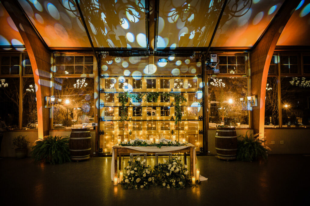 Evening reception space with sweetheart table and dramatic uplighting at The Conservatory at Sussex County Fairgrounds by Alex Kaplan Photography
