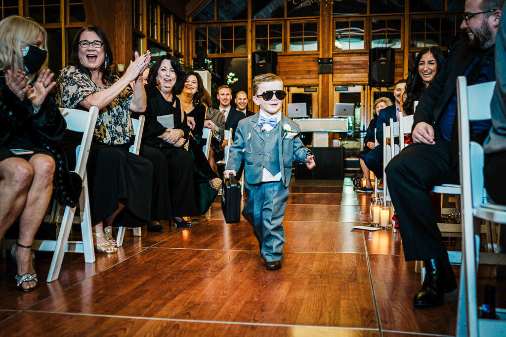 Ring bearer in sunglasses walking down the aisle at The Conservatory at Sussex County Fairgrounds wedding by Alex Kaplan Photography