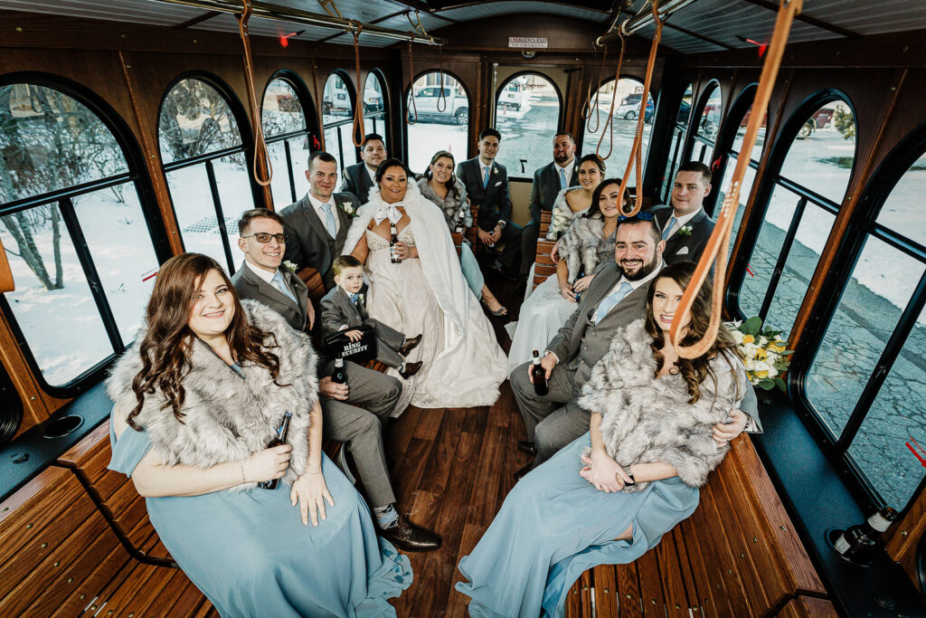 Full wedding party inside vintage trolley at Sussex County Fairgrounds winter wedding photographed by Alex Kaplan