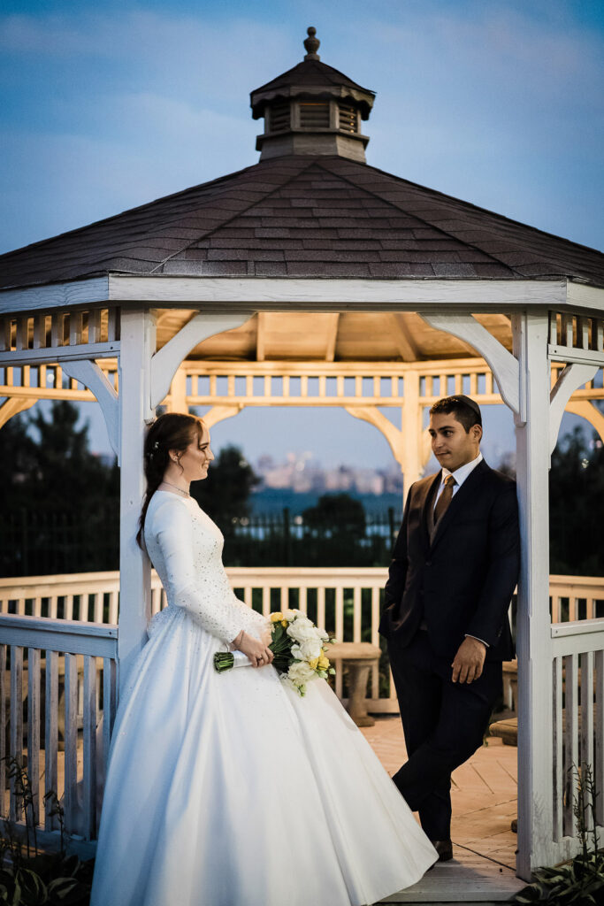 Couple portraits in gazebo with Manhattan skyline at Riverview Ballroom wedding venue Cliffside Park