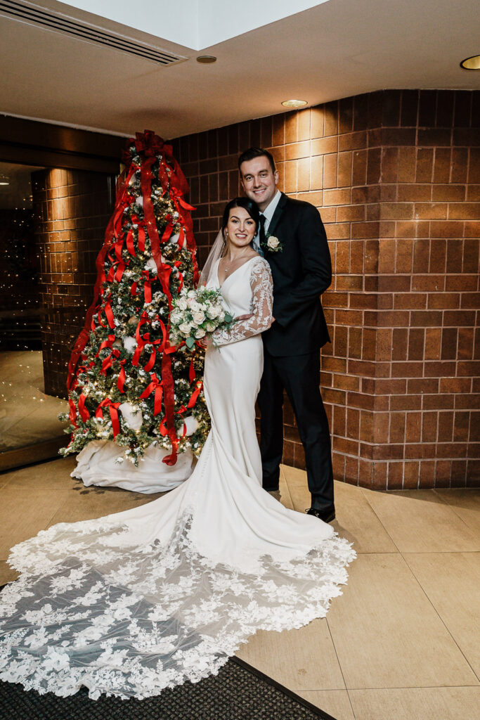 Couple with Christmas tree at Hyatt Regency Princeton by Alex Kaplan Photography