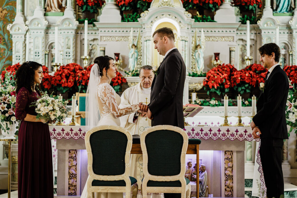 Couple exchanging vows at Catholic wedding ceremony by Alex Kaplan