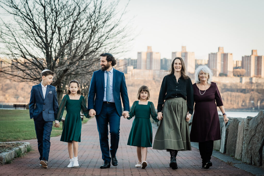 Multi-generational family walking at Ross Dock Fort Lee with Manhattan skyline background