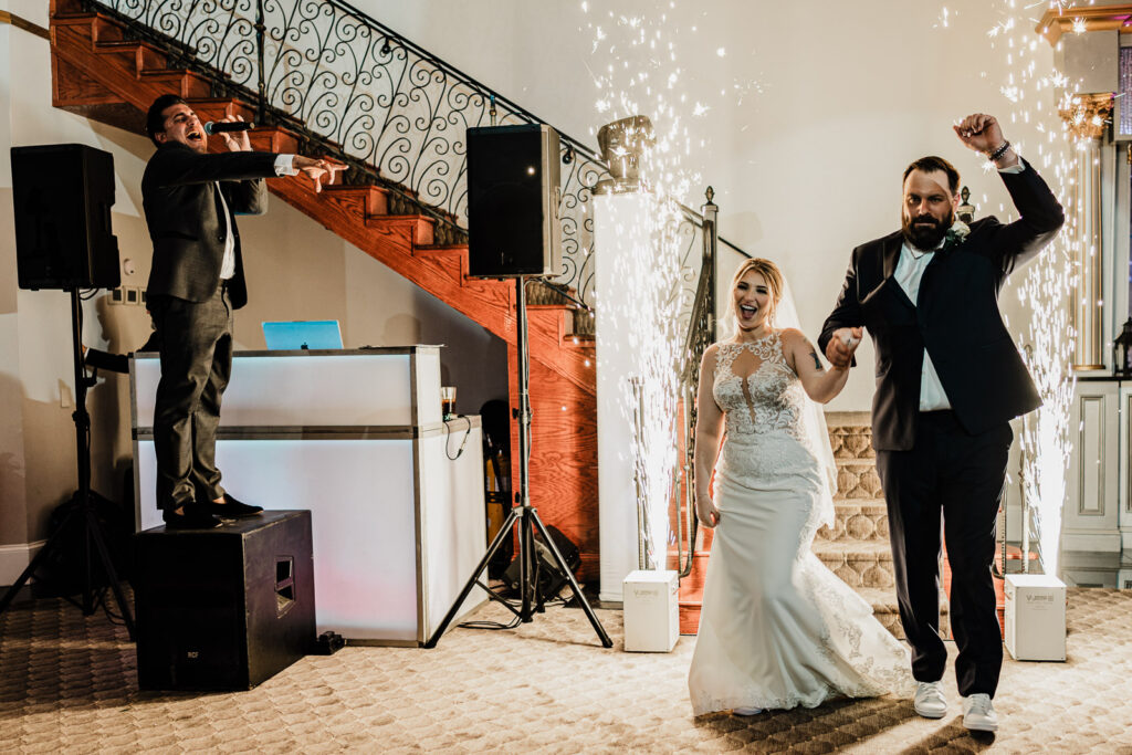 Dramatic grand entrance with cold spark fountains at Lucien's Manor Versailles ballroom captured by NJ wedding photographer Alex Kaplan