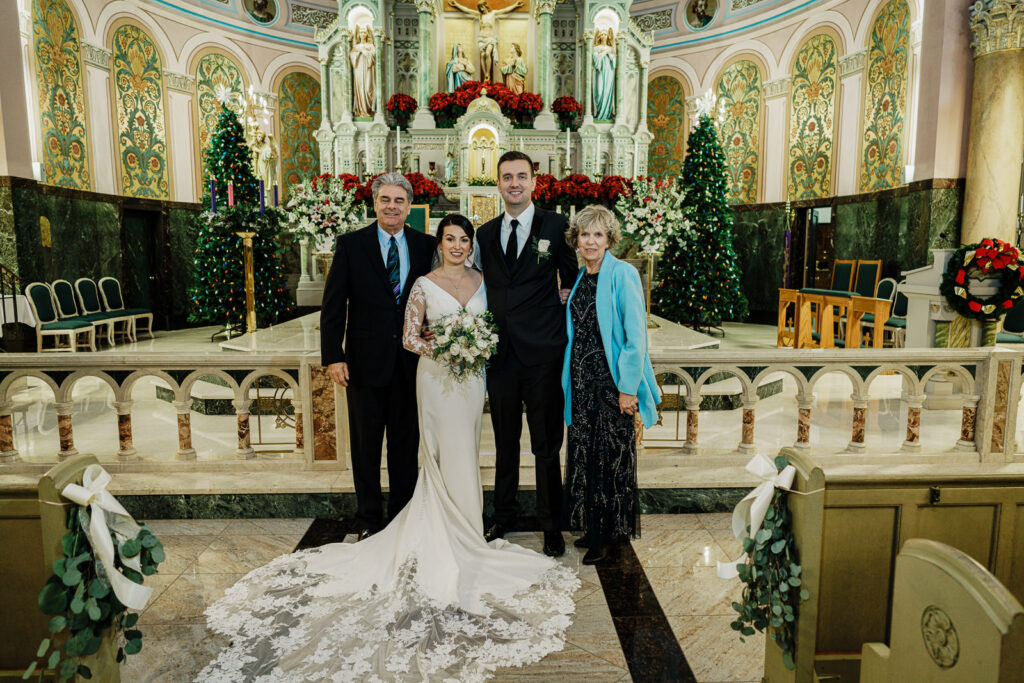 Groom with family at church after ceremony by Alex Kaplan Photography